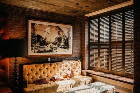 A room with a tufted sofa and a framed picture on the wall.